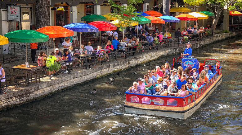 A boat cruising down the river in the La Villita neighborhood in San Antonio, Texas