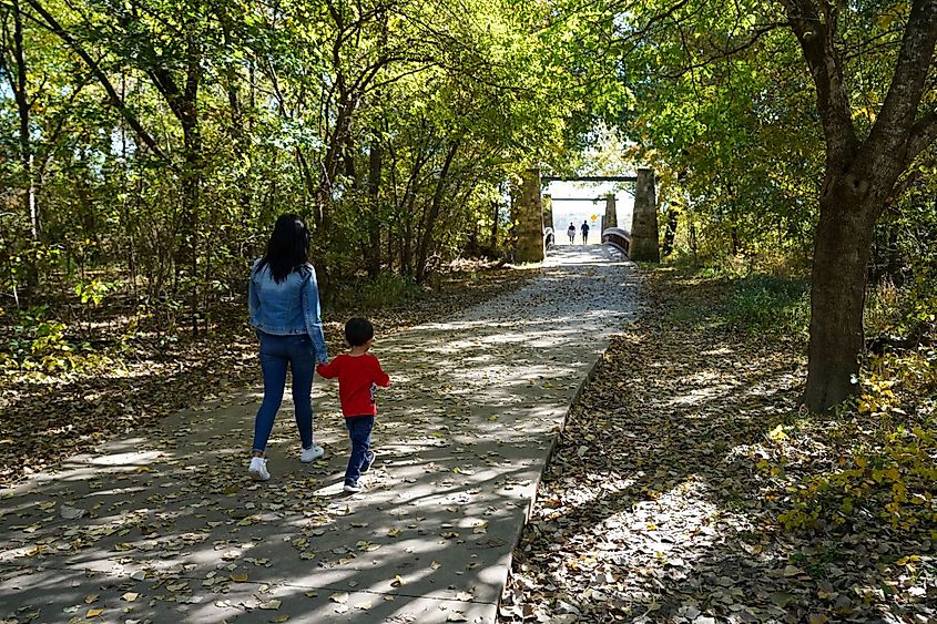 A woman walking with her son at the Oak Point Park in Plano, Texas.