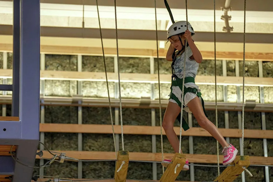 Abigail Maah walks an elevated indoor obstacle course at Camp For All. Staff can help people of all abilities be able to do the course. (Aaron E. Martinez/Austin American-Statesman)