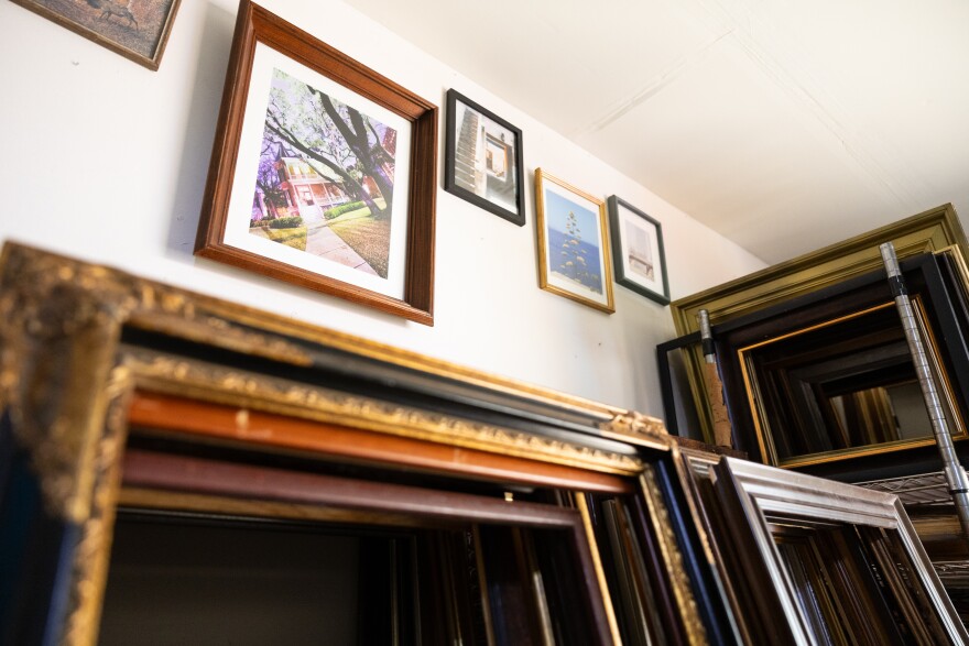 Frames with artwork hang above a set of empty frames.