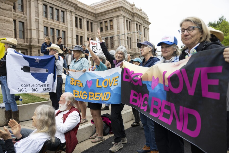 Protesters outside the Texas Capitol hold banners that say "Big Love Big Bend."