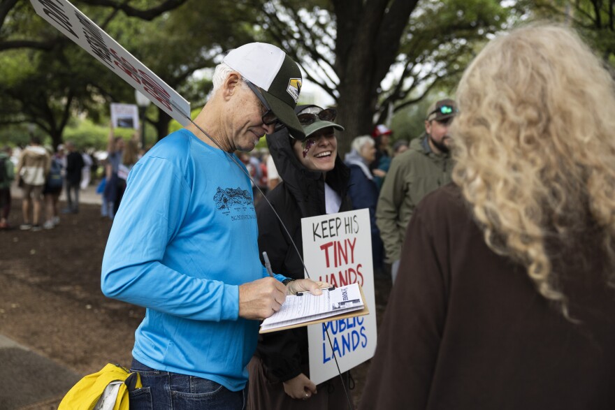 A man fills out a form while at a protest against proposed construction in the Big Bend region.