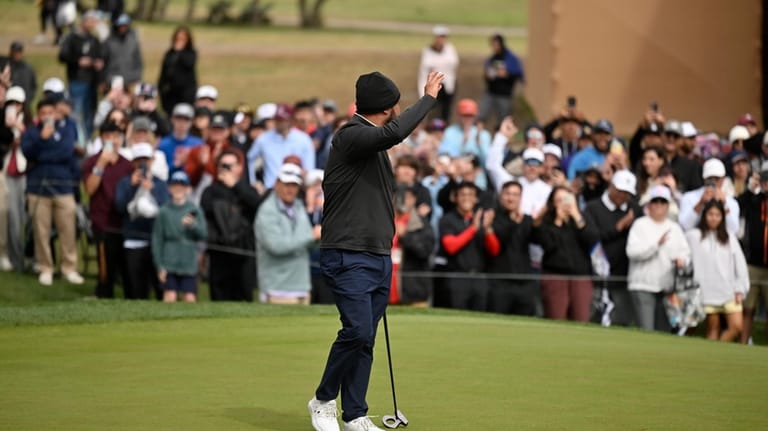 J.J. Spaun waves to fans on the 18th hole after...
