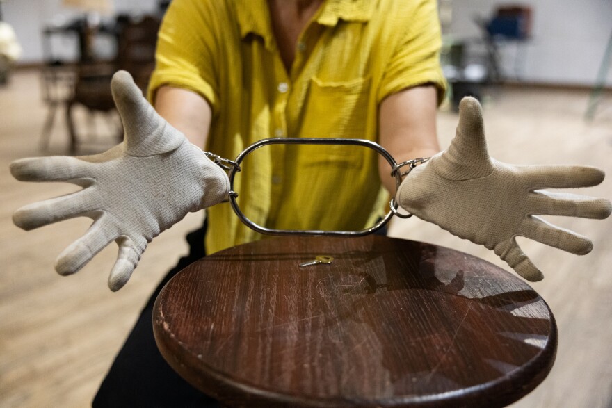 Katie Bender is locked in a chain during rehearsal for “Instructions for a Seance” at Bass Concert Hall rehearsal room on Monday, April 6, 2026.