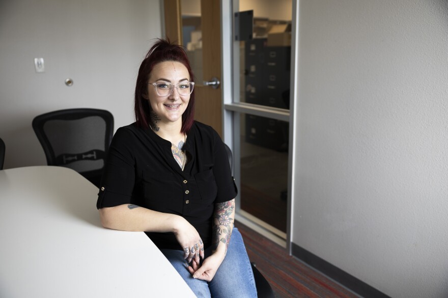 Jo Meier looks at the camera and smiles while sitting at a table.