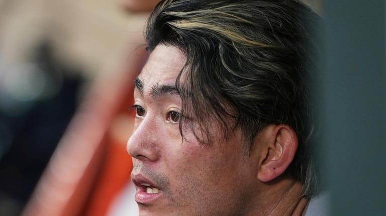 Houston Astros starting pitcher Tatsuya Imai sits in the dugout...