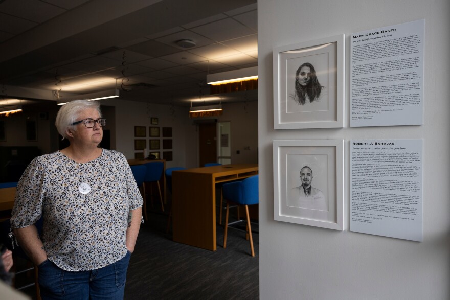 Annie Hernandez looks at two of the stories included in the Into Light Texas exhibition inside Walter Webb Hall. 