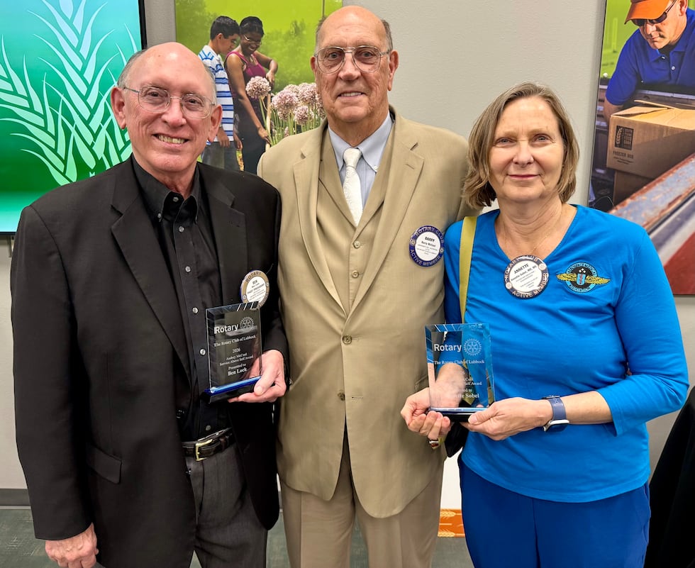 Barry McCool, center, flanked by Ben Lock and Annette Sobel, the first two recipients of the...