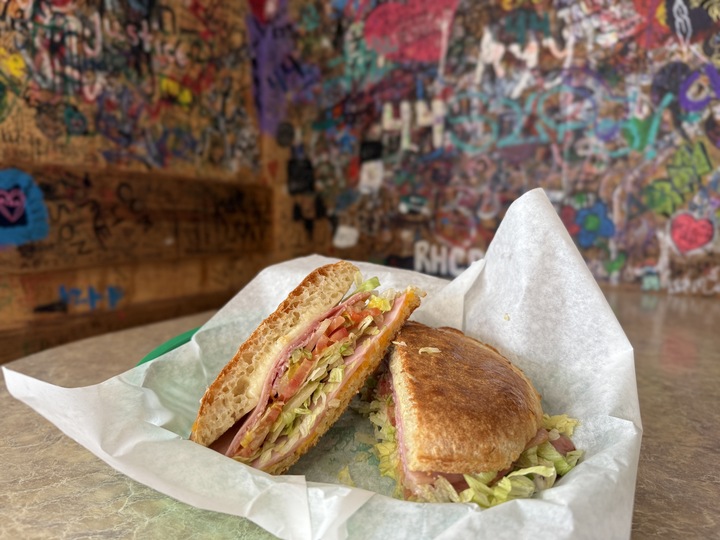 Texas State student Griffin Fisher reads a notice posted outside Alvin Ords in San Marcos on April 14, 2026, stating the restaurant is temporarily closed for an "unknown period of time" due to unforeseen circumstances.