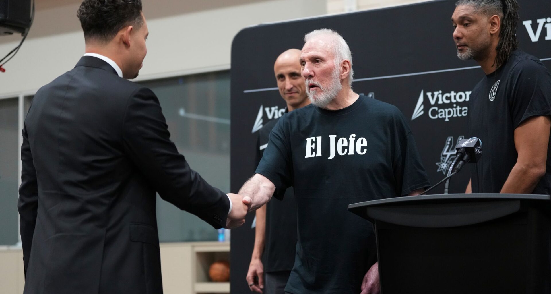 With the help of former players Manu Ginobili, back left, and Tim Duncan, right, former San Antonio Spurs head coach Gregg Popovich, center, introduces Mitch Johnson, left, as the new head coach of the San Antonio Spurs NBA basketball team, in San Antonio, Monday, May 5, 2025.