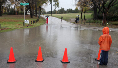 Spectators wait in the rain for the first wave of runners to enter the White Rock Lake area during the 42nd MetroPCS Dallas White Rock Marathon December 4, 2011.