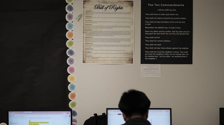 Students work under Ten Commandments and Bill of Rights posters...