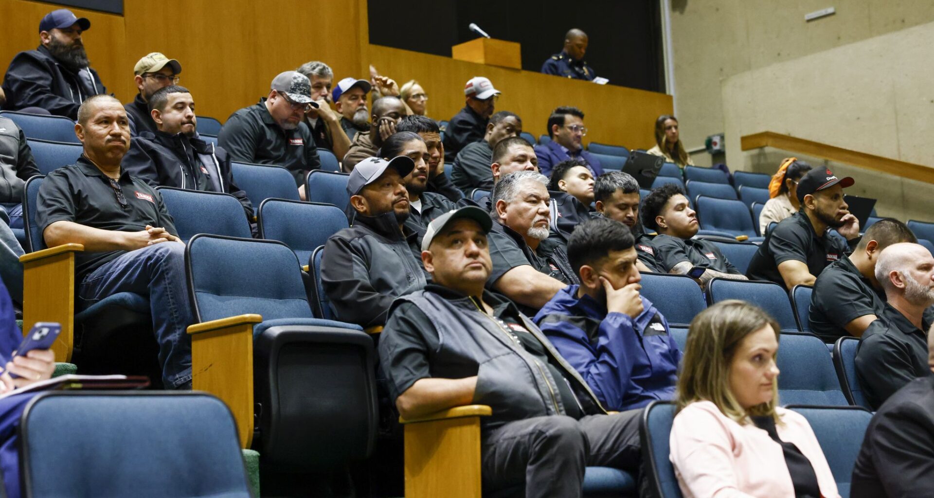 People wearing TAMKO branded gear attend a Dallas City Council meeting on Wednesday, April 22, 2026, at Dallas City Hall.
