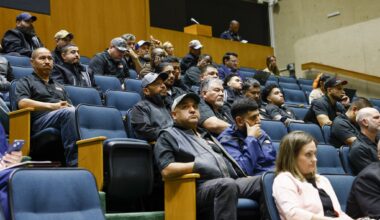 People wearing TAMKO branded gear attend a Dallas City Council meeting on Wednesday, April 22, 2026, at Dallas City Hall.