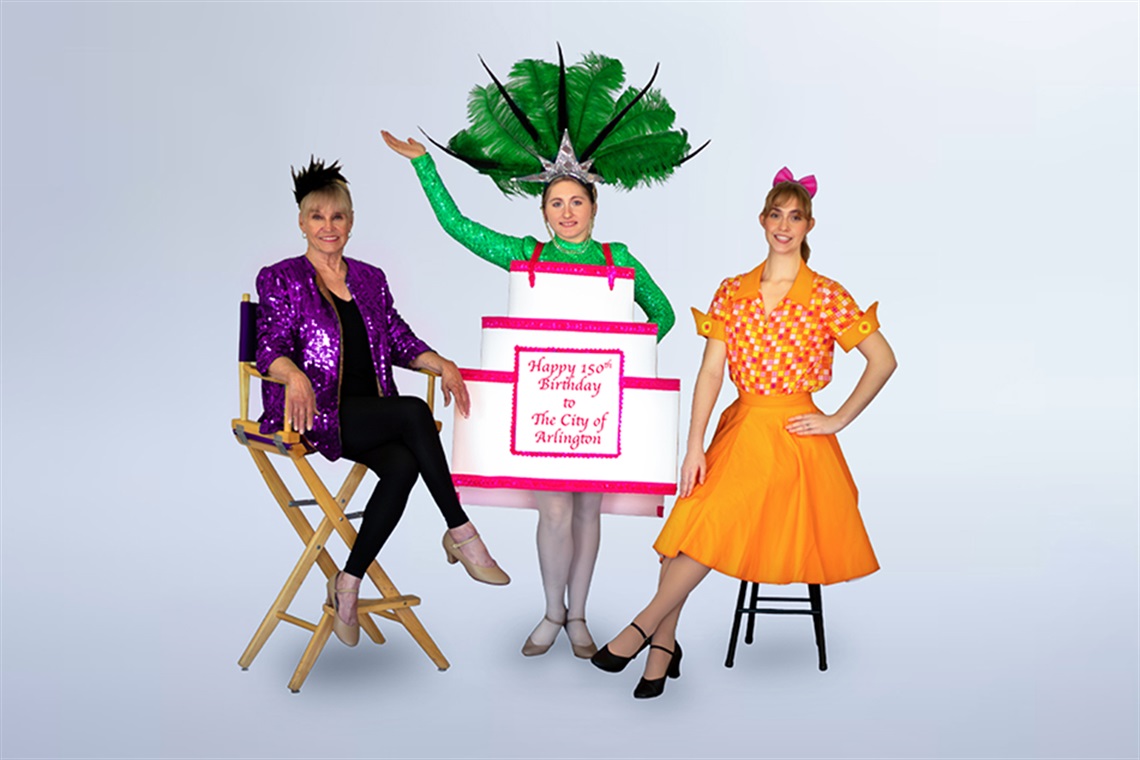 Two women sitting and a women with a birthday cake that says 