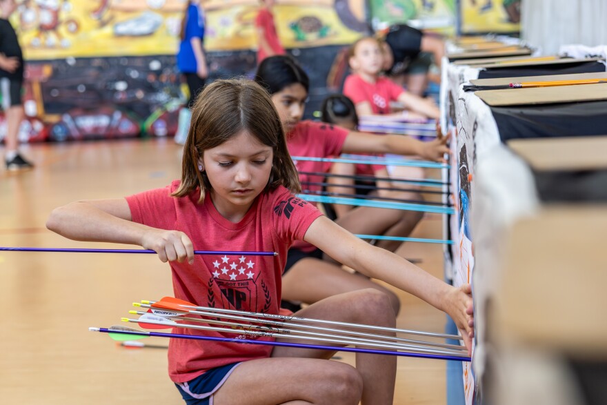 Fifth grader Etta Moskowitz collects her arrows from the target during after-school archery practice on Monday, April 13, 2026, at Highland Park Elementary School in Austin, Texas. 