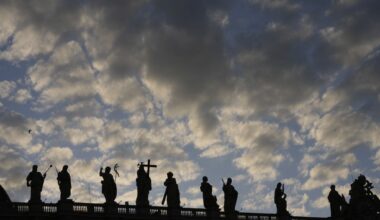 Statues of the Bernini Colonnade are silhouetted against a cloudy sky during the cardinals' conclave to elect a new pope, at the Vatican, Wednesday, May 7, 2025. (AP Photo/Luca Bruno)
