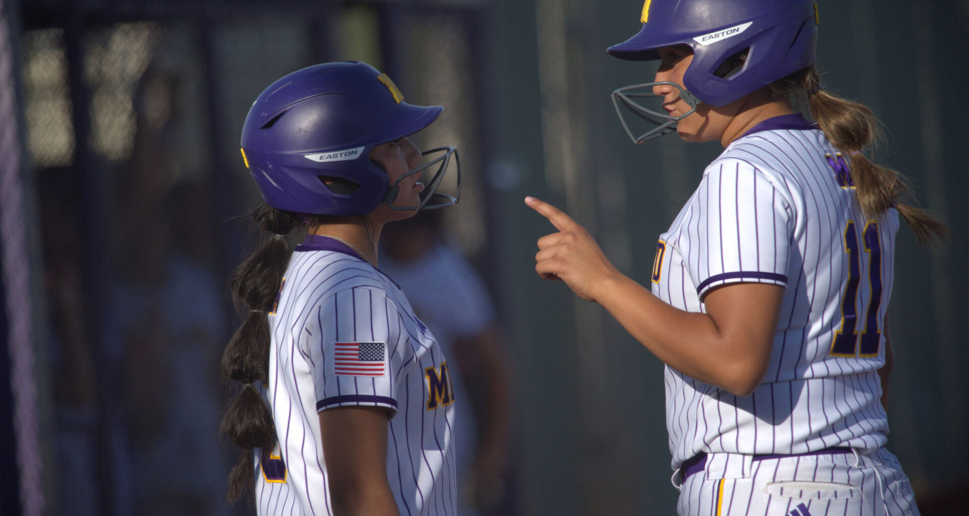 Midland High's Jade Rodriguez (right) gives Gabby Gomez the scouting report on the El Paso Montwood pitcher, April 24, 2026, at Martin Field. 