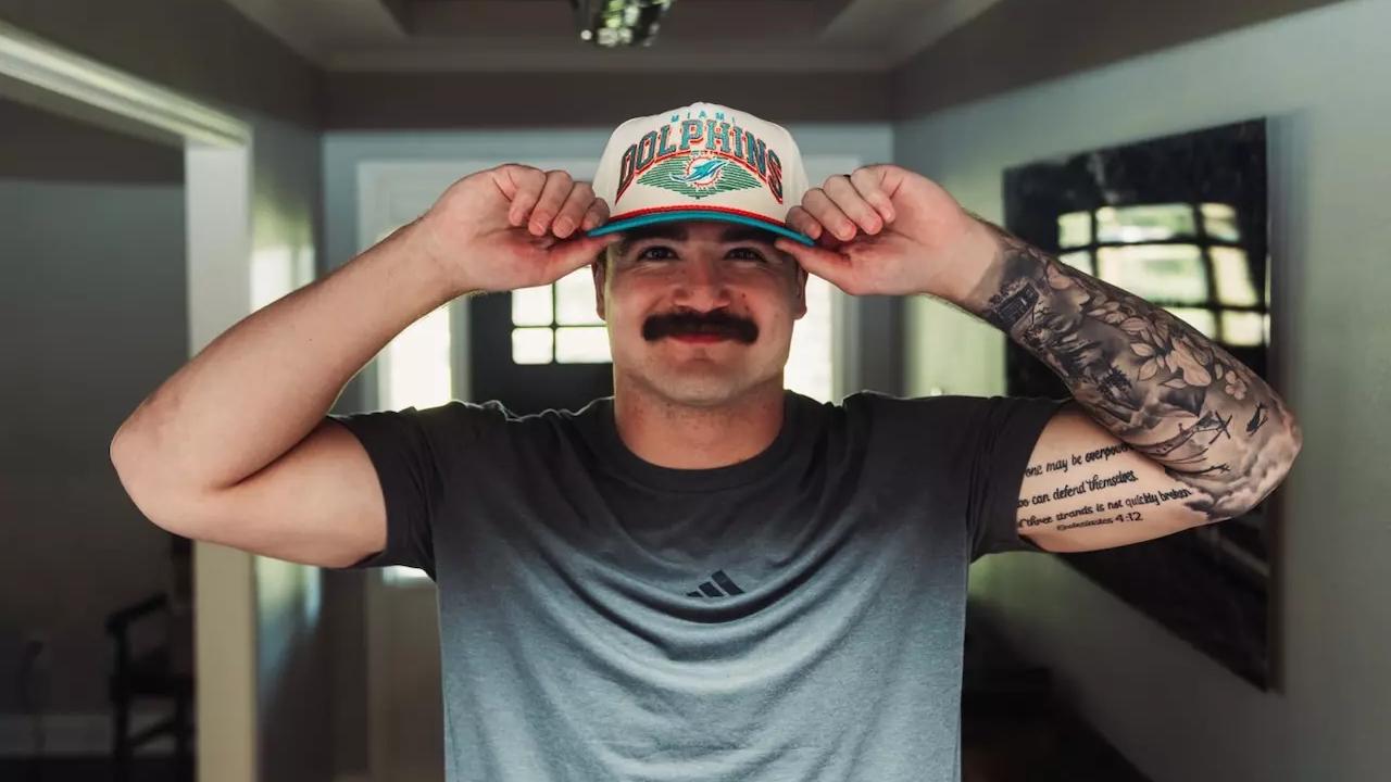 Caleb Douglas donning Miami Dolphins hat with Texas Tech coach Juice Johnson