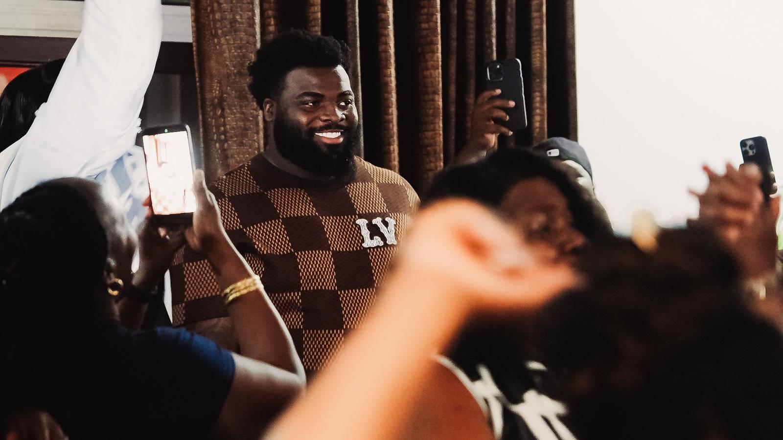 Caleb Douglas donning Miami Dolphins hat with Texas Tech coach Juice Johnson