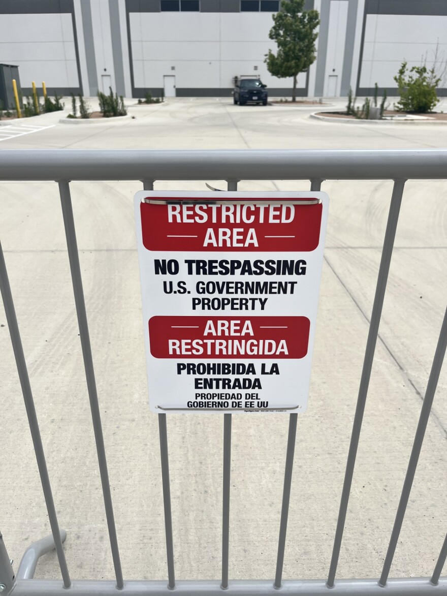 A sign at the gate of a proposed ICE processing facility on southeast Loop 410 in San Antonio. A lone government vehicle sits in the parking lot of the massive facility on April 25th, 2026