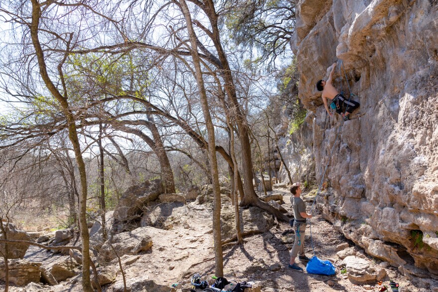 Tim Ramsay, left, watches as David Yang climbs a route named Trash Can Man on the Gus Fruh wall at the Barton Creek Greenbelt.
