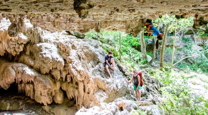 A person lead-climbs at Reimers Ranch while two other stand by.