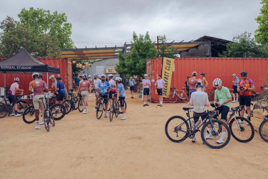Cyclings gather with their bikes outside a restaurant.