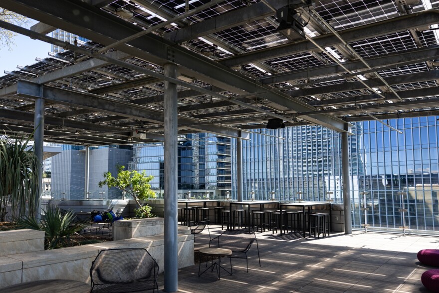 The rooftop garden at the Central Library, featuring a shaded overhang, seats and plants.