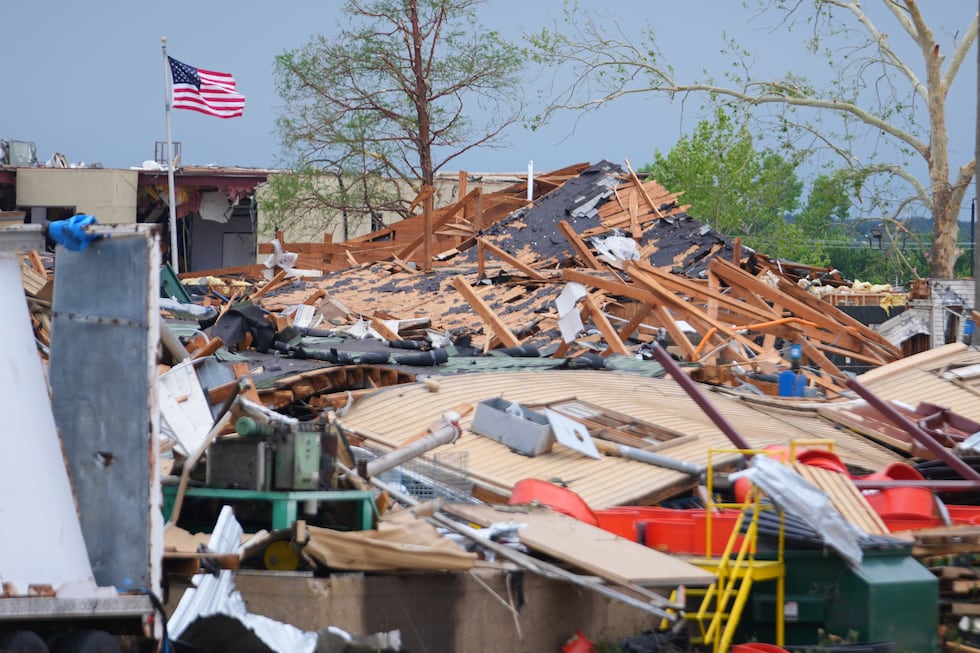 A United States flag waves over debris following a storm in Mineral Wells, Texas, Wednesday,...