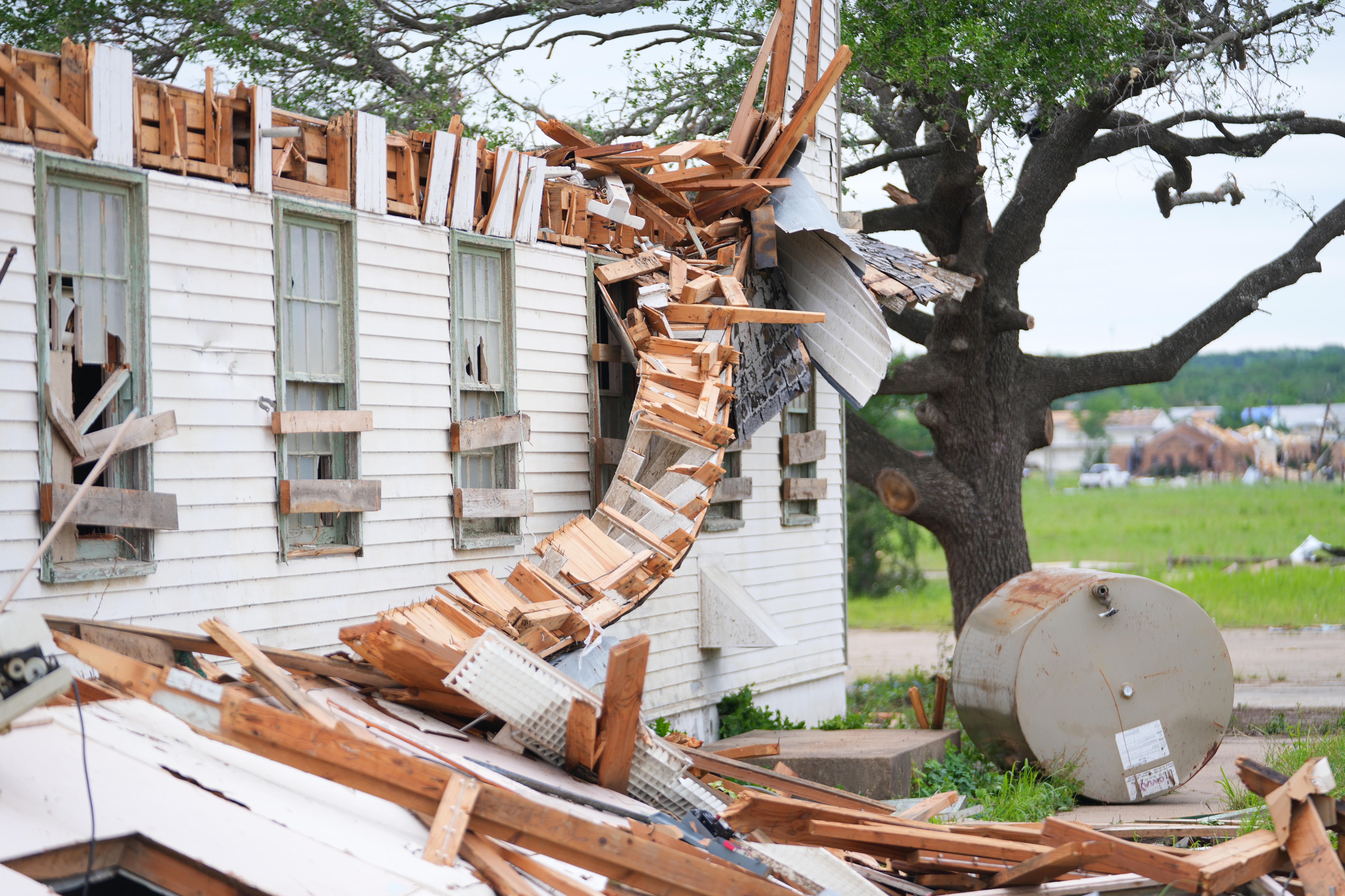A damaged home is surrounded by debris following a storm...