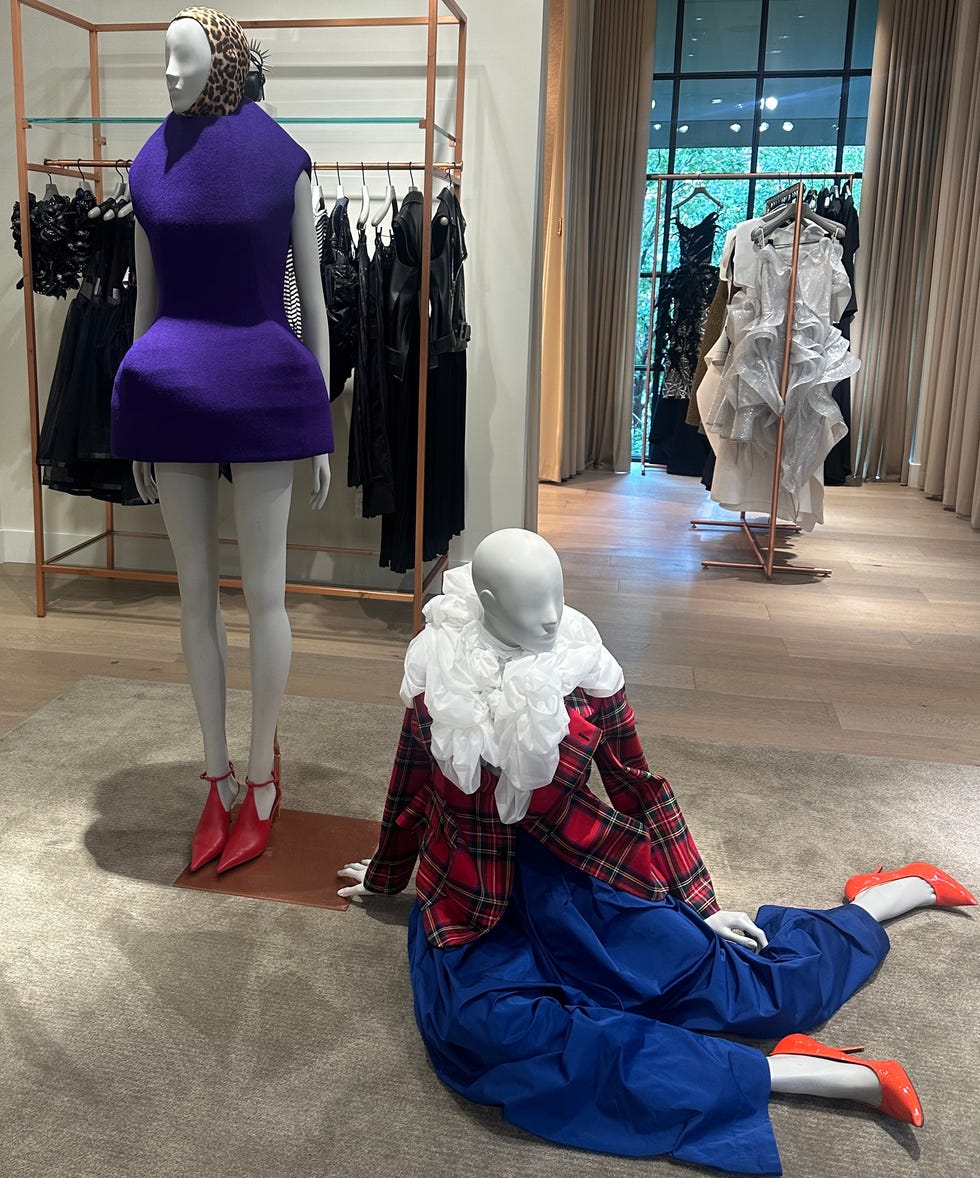 Fashion display featuring two mannequins with distinctive outfits in a retail setting.