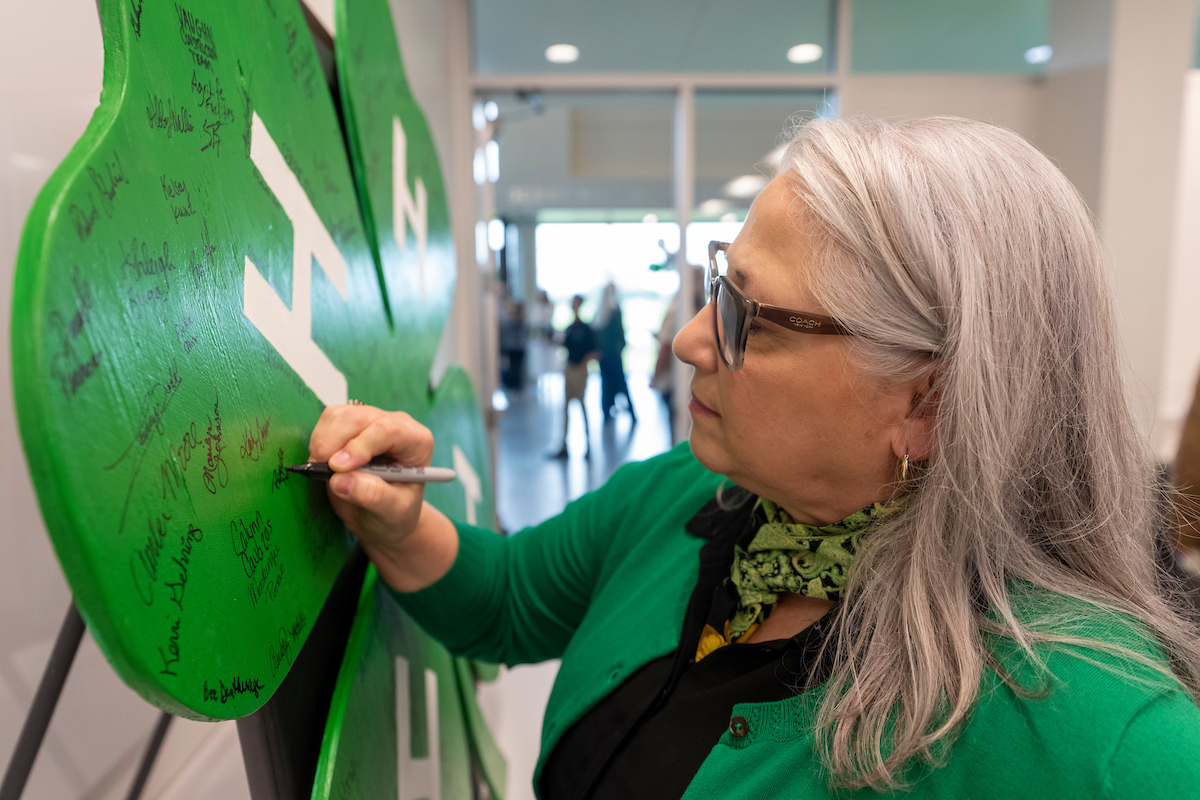 A woman signs a Texas 4-H placard.