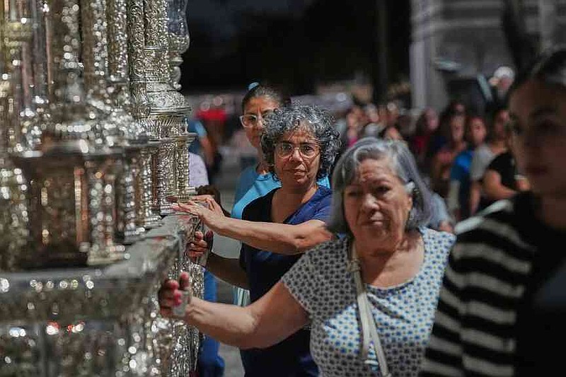 Members of the Corpus Christi Catholic Church push a large float that will carry the Lady of Hope Macarena during a rehearsal of their Good Friday procession Monday, March 23, 2026, in Miami, Fla. (AP Photo/Marta Lavandier)