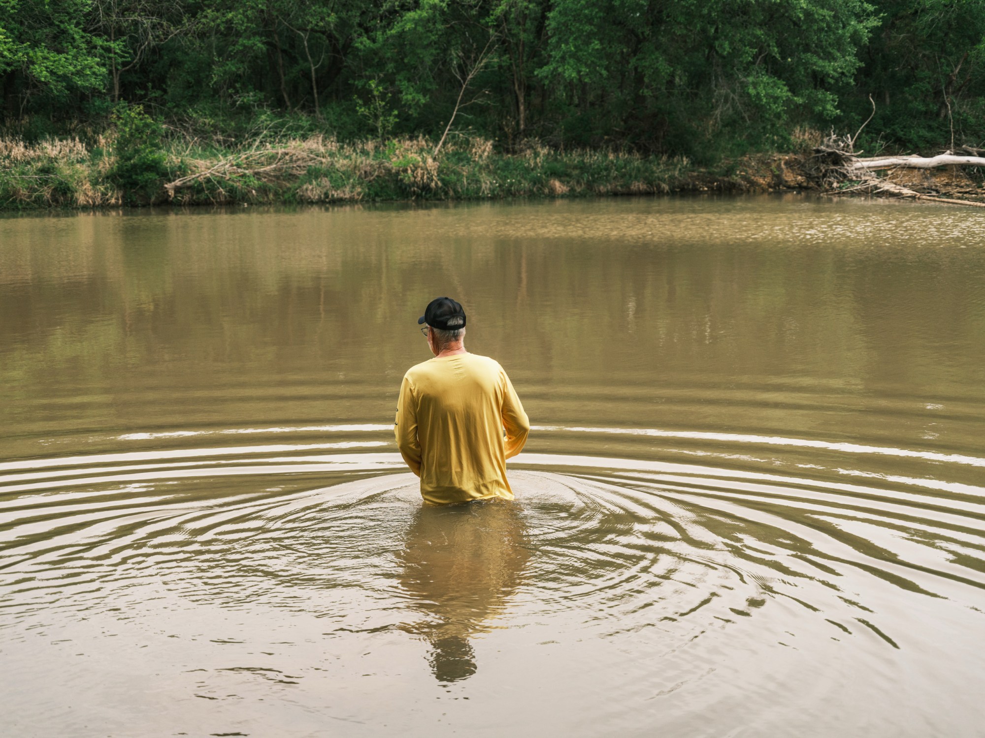 Jimmy Dorrell wades into the chilly Middle Bosque River before the baptism service on Easter Sunday.