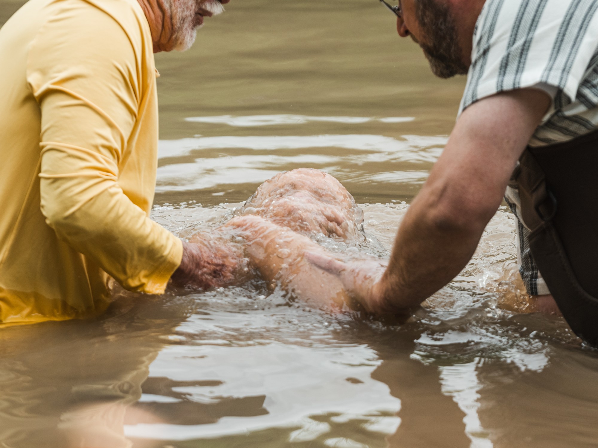 Janet Constantine is baptized in the Middle Bosque River by Jimmy Dorrell and Kevin Brown during Church Under the Bridge’s Easter service west of Waco.