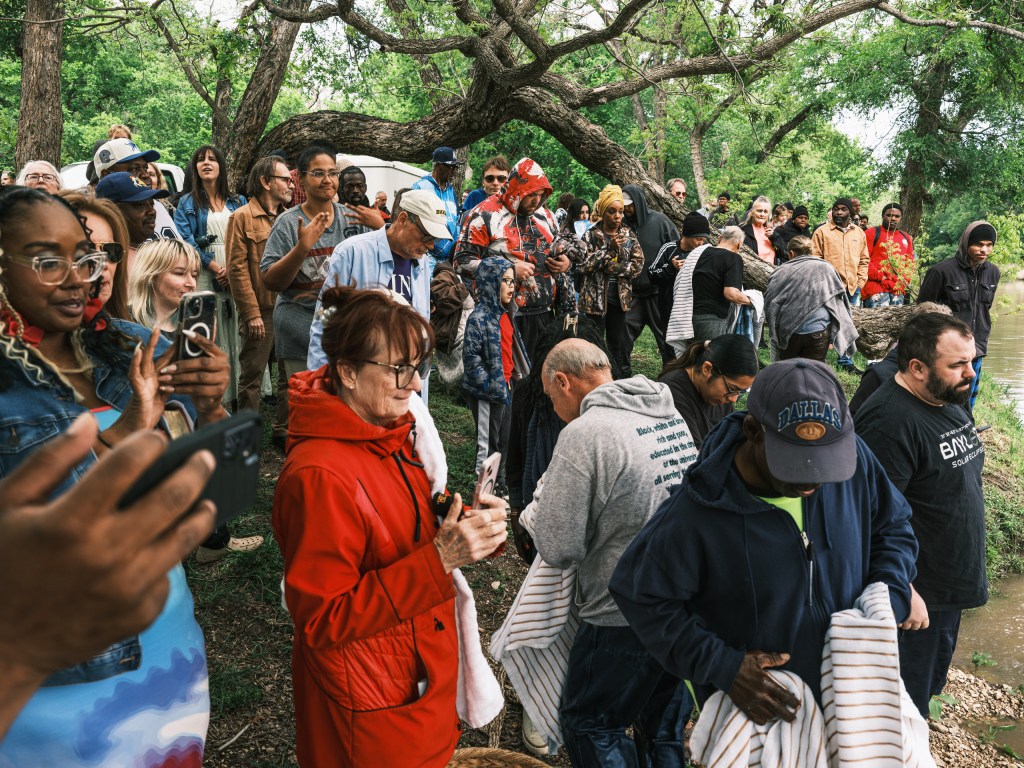 Janet Dorrel (center) watches as a dozen people are baptized by Jimmy Dorrell and Kevin Brown on Easter Sunday.