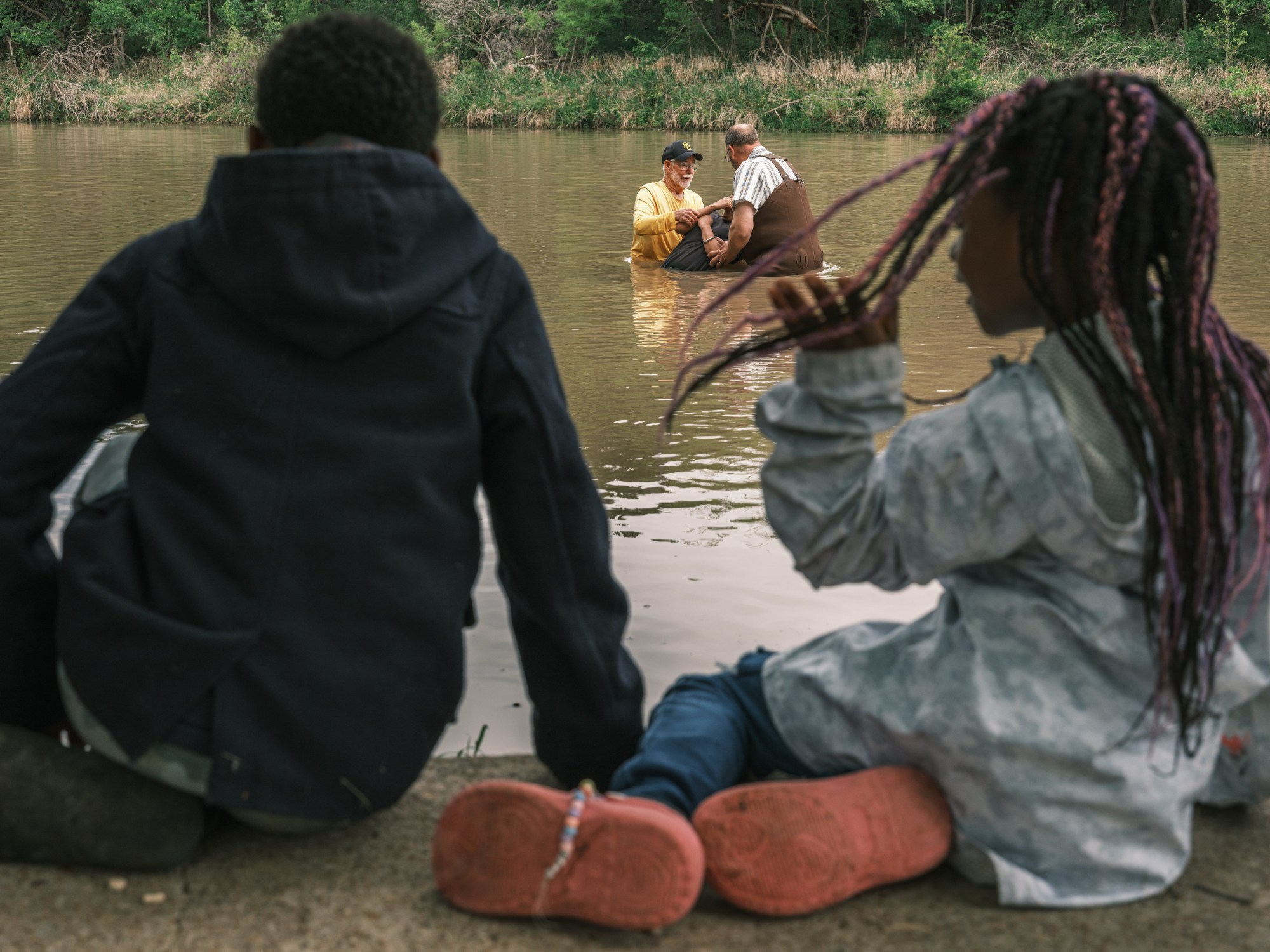 Kids watch Jimmy Dorrell and Kevin Brown baptize 12 people during Church Under the Bridge’s Easter service west of Waco.