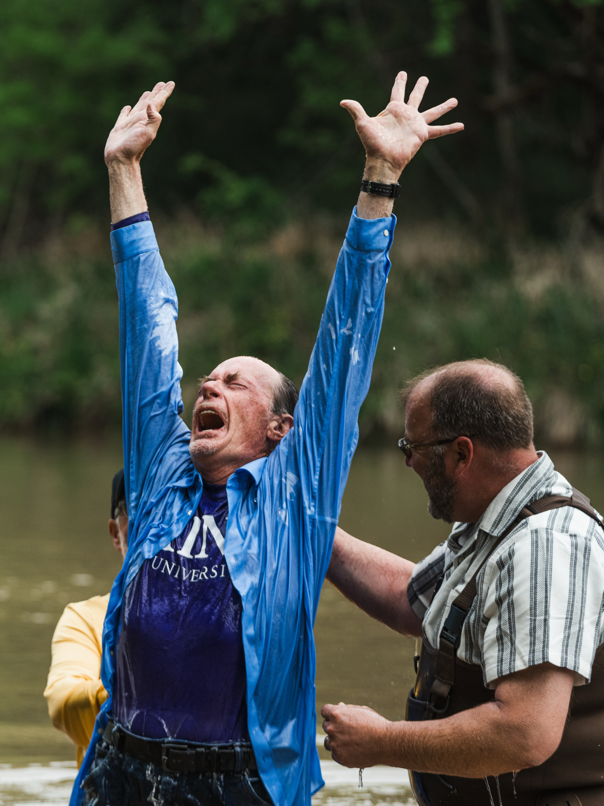 Michael Dionne shouts after he is baptized in the Middle Bosque River by Jimmy Dorrell and Kevin Brown.