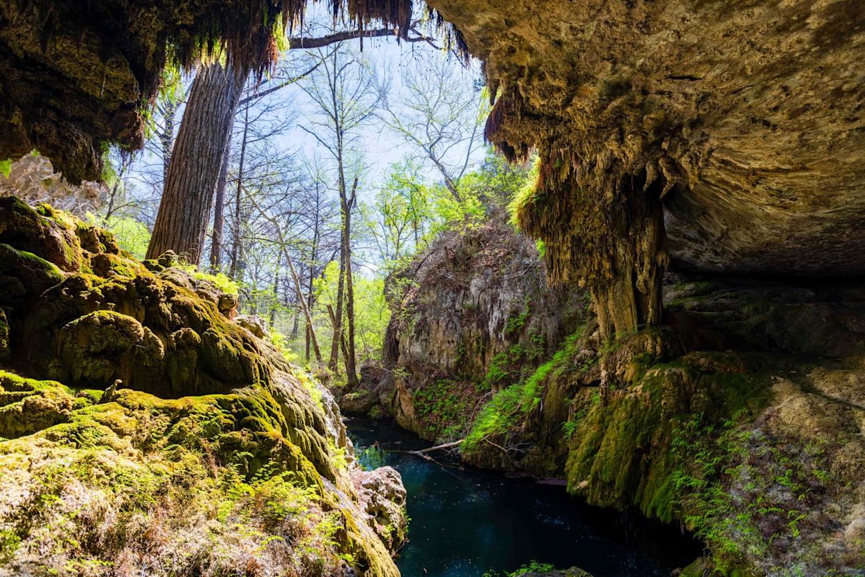 the grotto at west cave discovery center with water below and the overhang of a cave above