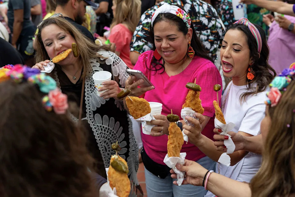 Araceli Bermea, from left, Jeanette Lopez and Marisol Lopez, enjoy chicken on a stick with their friends during the opening night of "A Night In Old San Antonio" (NIOSA) at La Villita Historic Arts Village District in April 2024 in San Antonio. (Salgu Wissmath/San Antonio Express-News file photo)