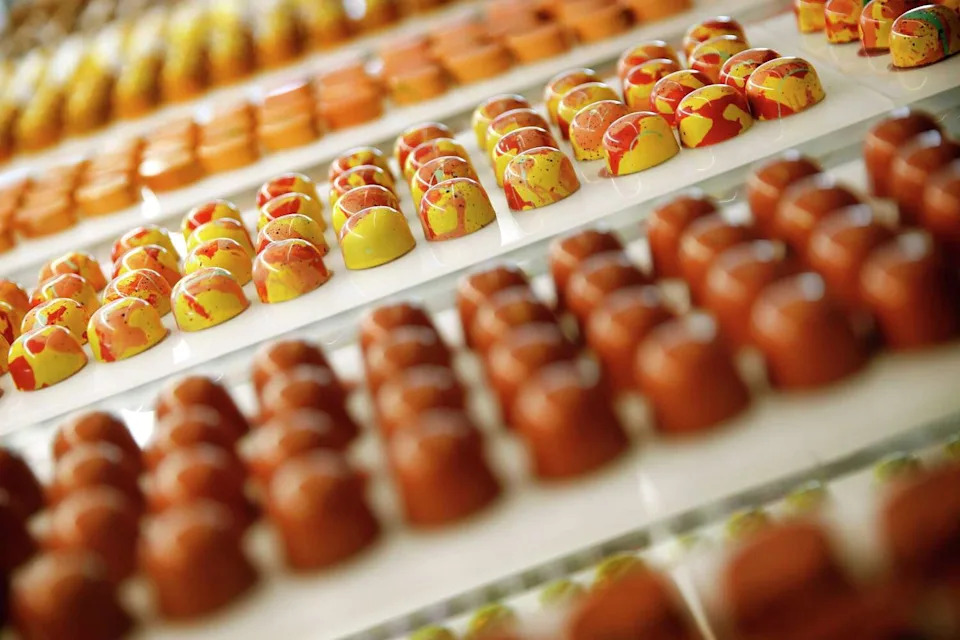 Passion Fruit (center) and other flavors of chocolate bonbons are pictured in a display case at Kate Weiser Chocolate at her Trinity Groves location in Dallas. (Tom Fox/Staff Photographer)