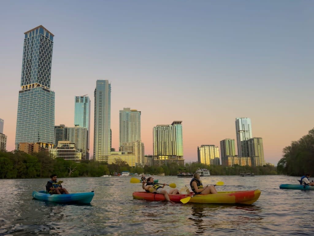 the austin texas skyline viewed from lady bird lake in a kayak