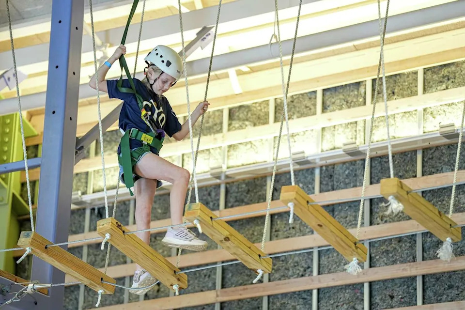 Emeline Kelly walks an elevated indoor obstacle course at Camp For All. The obstacle courses are a favorite of campers. (Aaron E. Martinez/Austin American-Statesman)