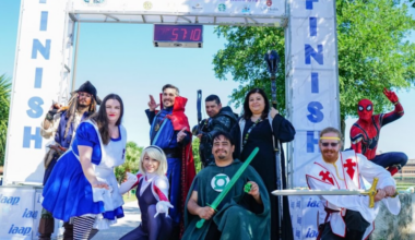 Runners at the finish line of a race dressed up in superhero customes.