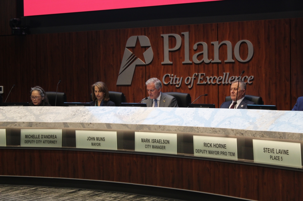 Mayor Pro Tem Maria Tu, Deputy City Attorney Michelle D'Andrea, Mayor John Muns, and City Manager Mark Israelson sit behind the dais in the Plano City Council chambers.