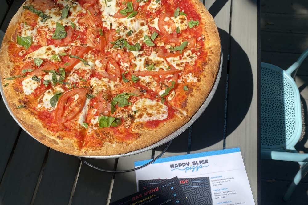 Classic pies at Happy Slice Pizza include the Margherita pizza ($25.99), which can be served on a gluten-free 14-inch crust. (Katlynn Fox/Community Impact)