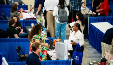 People speaking at a career fair booth