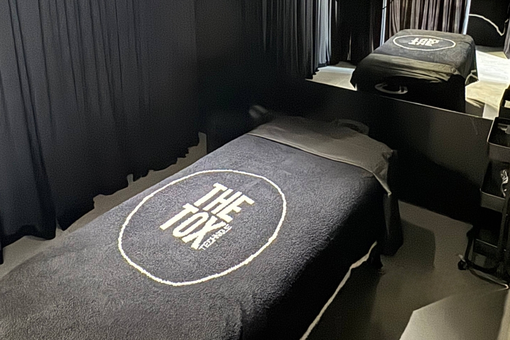 Interior of spa room featuring The Tox-branded bed linens.