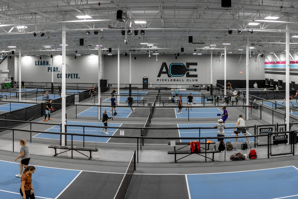 Interior of a pickleball business featuring multiple blue pickleball courts.